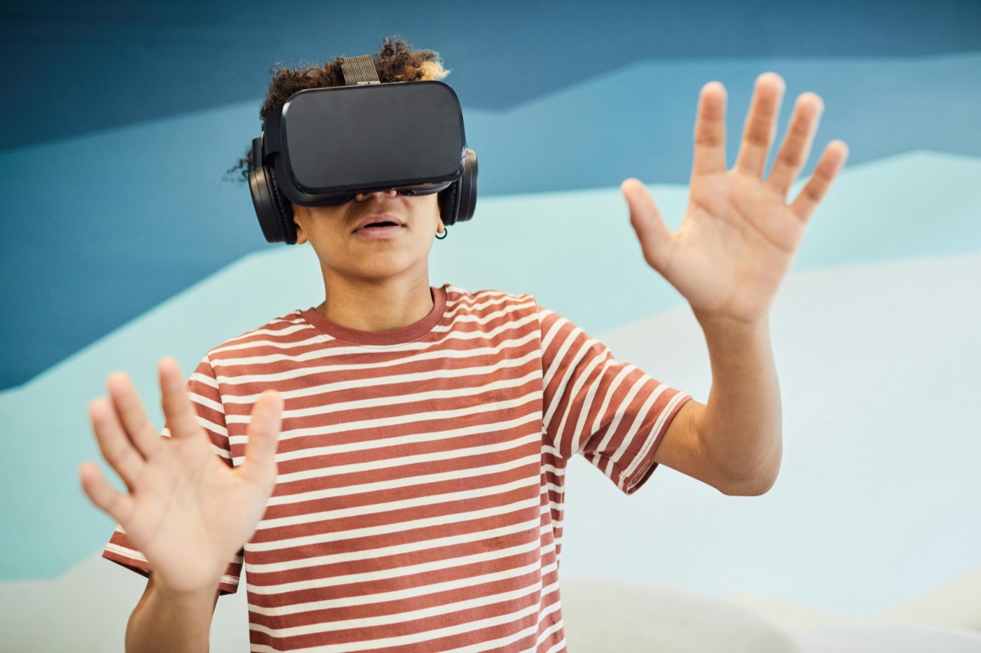 Leerling met VR-bril die met de handen in de ruimte beweegt